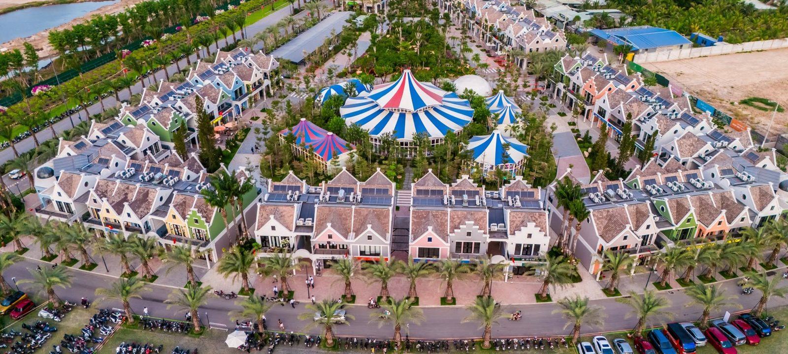 Ảnh flycam thực tế Eco Bazaar: dãy nhà phố nhiều màu quanh lều xiếc xanh đỏ